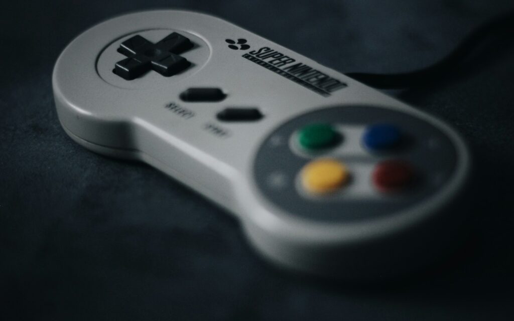 Controller del Super Nintendo con croce direzionale e tasti colorati su fondo scuro