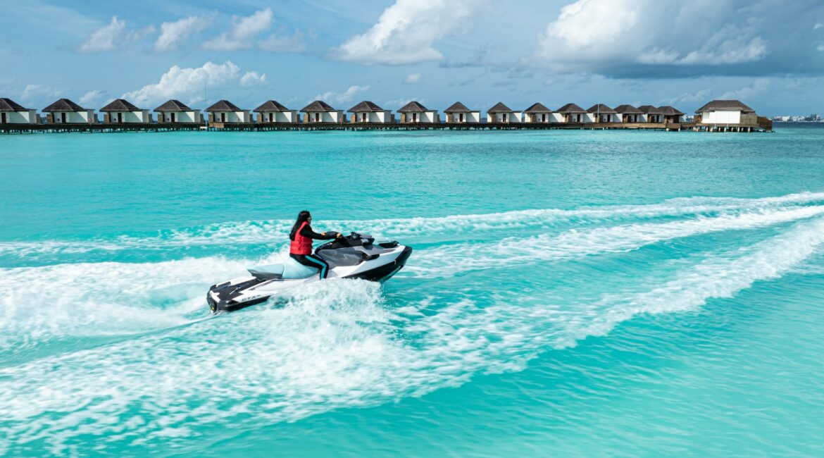 Moto d'acqua sul mare turchese davanti ai bungalow di un resort tropicale