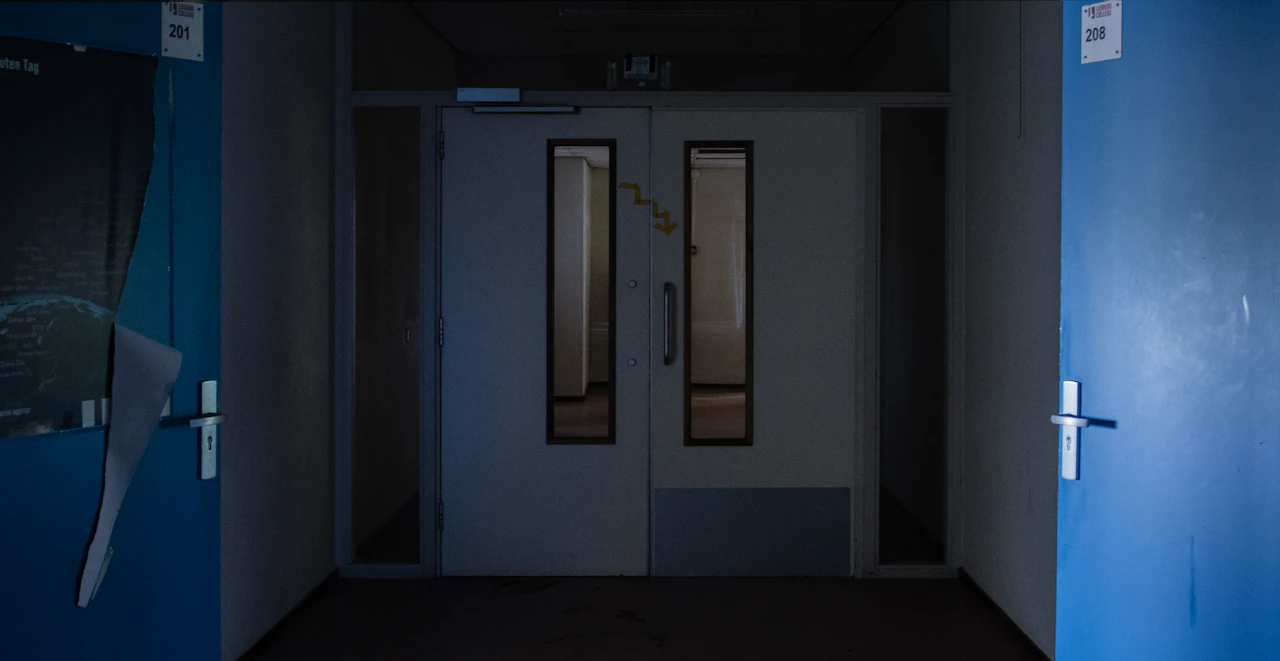 corridoio buio che termina con una porta blu