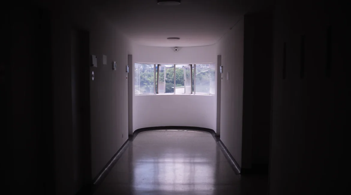 corridoio buio che conduce a una finestra ad arco